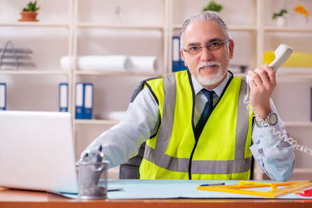 Aged construction engineer working in the officeの写真素材