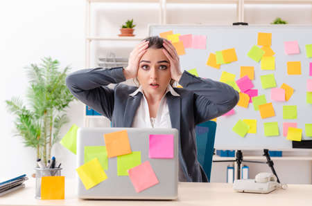 Young female employee in conflicting priorities conceptの写真素材