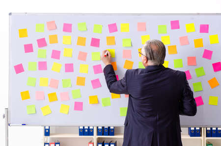 Aged man employee in conflicting priorities concept