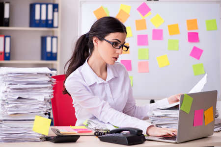 Young female employee in conflicting priorities conceptの写真素材