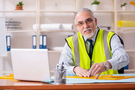 Aged construction engineer working in the office