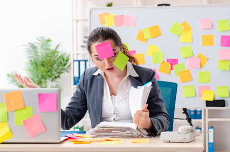 Young female employee in conflicting priorities conceptの写真素材