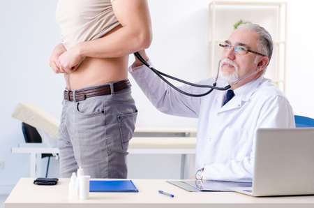 Young male patient visiting old doctorの写真素材