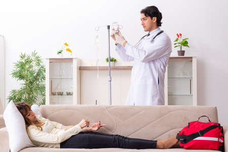 Young handsome doctor visiting female patient at homeの写真素材