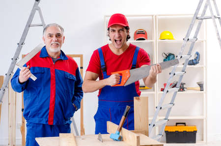 Two professional contractors laying flooring at homeの写真素材