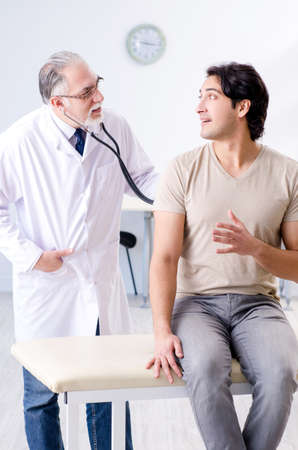 Young male patient visiting old doctorの写真素材