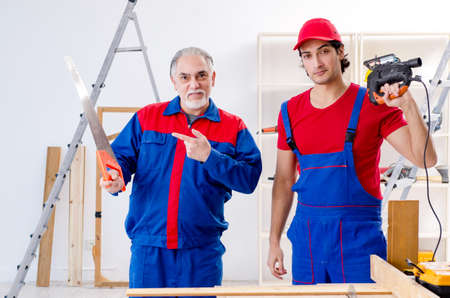 Two professional contractors laying flooring at homeの写真素材