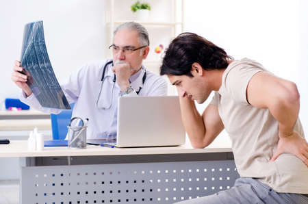 Young man visiting old male doctor radiologist