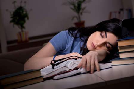 Young female student preparing for exams at night timeの写真素材