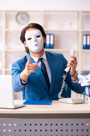 Male employee in the office in industrial espionage conceptの写真素材