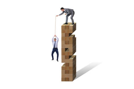 Businessman helping colleague with ropeの写真素材