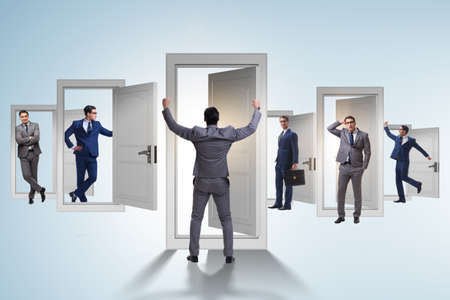 Businessman in uncertainty concept with many doorsの写真素材