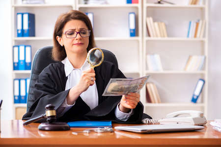 Middle-aged female doctor working in courthouseの写真素材