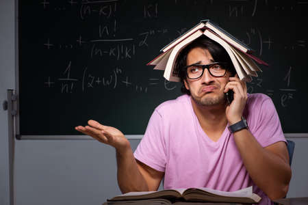 Young male student sitting in classroomの写真素材