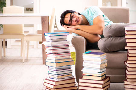 Male student with many books at homeの写真素材