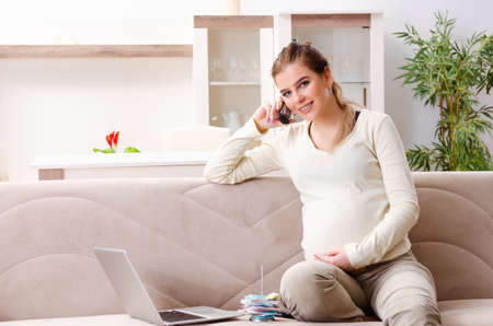 Young pregnant woman in budget planning concept