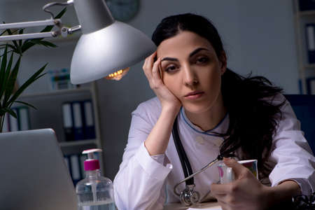 Young female doctor working at night shiftの写真素材