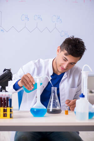 Young chemist sitting in the labの写真素材
