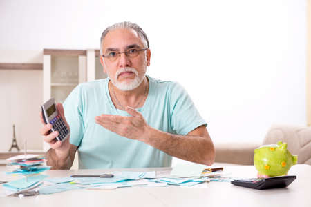 White bearded old man in budget planning conceptの写真素材