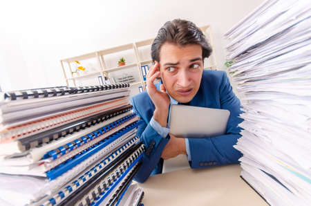 Young handsome businessman unhappy with excessive work
