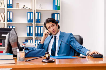 Young handsome judge sitting in courtroomの写真素材