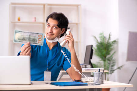 Young handsome doctor working in the clinicの写真素材