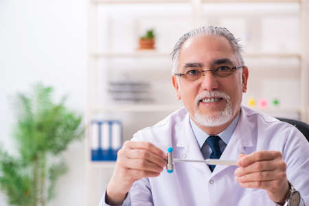 Aged male doctor with hammer