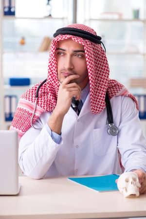 Arab doctor with humans skullの写真素材