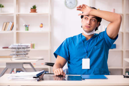 Young handsome doctor working in the clinicの写真素材