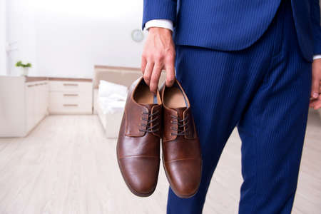 Young handsome businessman choosing shoes at home