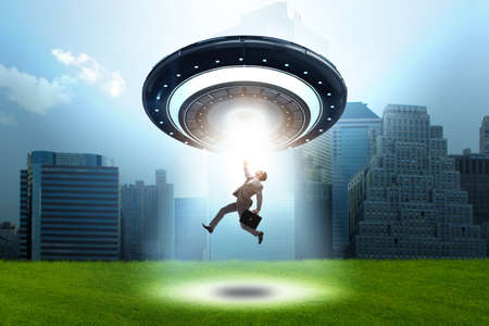 Flying saucer abducting young businessmanの写真素材