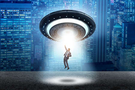 Flying saucer abducting young businessmanの写真素材