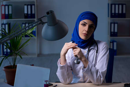 Arab female doctor working in the clinic at nightの写真素材