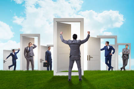 Businessman in uncertainty concept with many doorsの写真素材