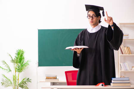 Graduate student in front of green board