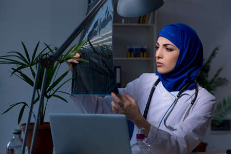 Arab female doctor working in the clinic at nightの写真素材