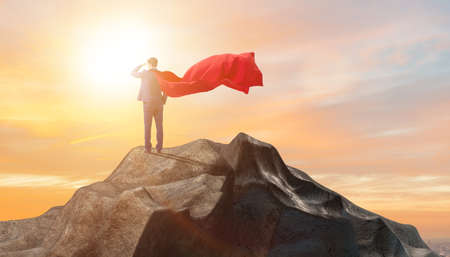Superhero businessman on top of mountain