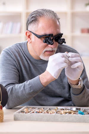 White bearded old jeweler at workshop