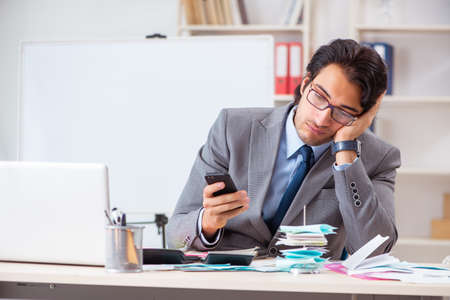 Young handsome businessman in budget planning conceptの写真素材