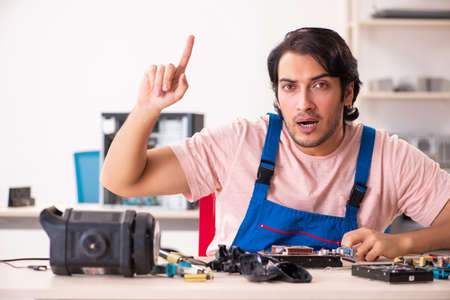 Young male contractor repairing computerの写真素材