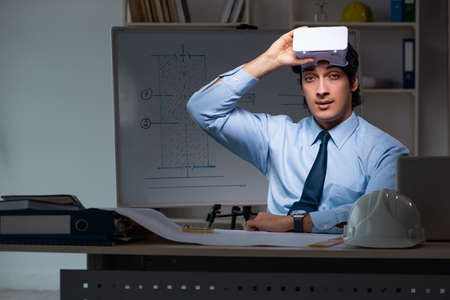 Young male architect working night at officeの写真素材