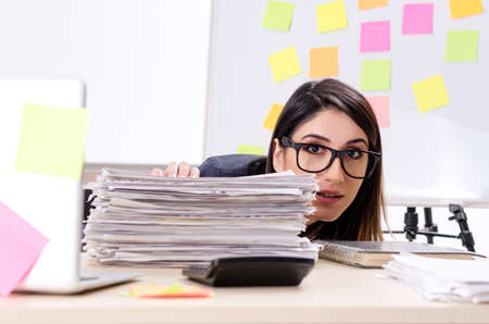 Young female employee in conflicting priorities conceptの写真素材