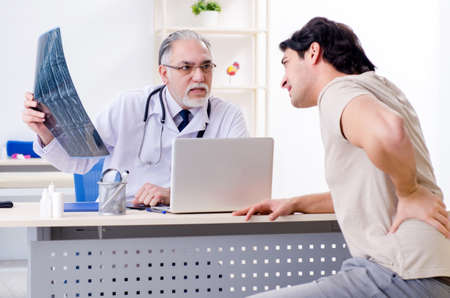 Young man visiting old male doctor radiologist