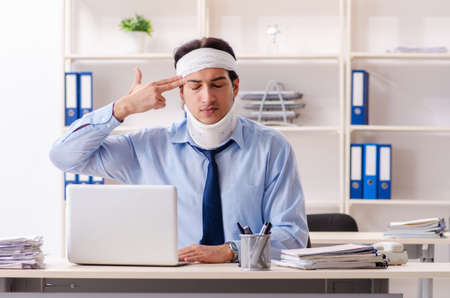 Young injured male employee working in the officeの写真素材