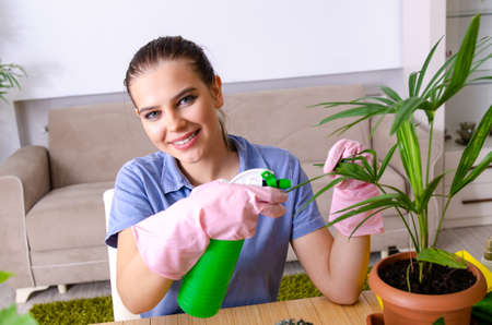 Young female gardener with plants indoors