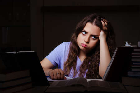 Young female student preparing for exams late at home