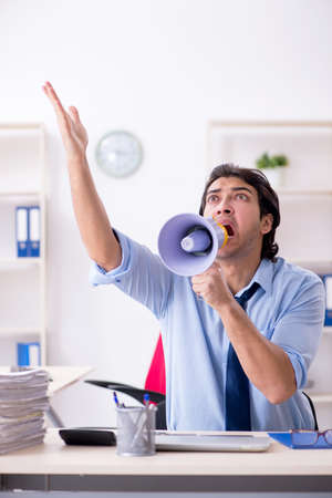 Young male businessman employee unhappy with excessive workの写真素材