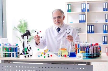 Old male chemist working in the lab