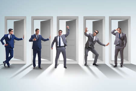 Businessman in uncertainty concept with many doorsの写真素材