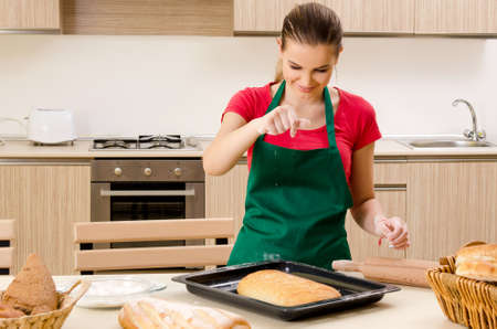Young female baker working in kitchen